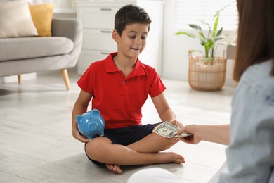 Photo of Mother giving pocket money to her son at home