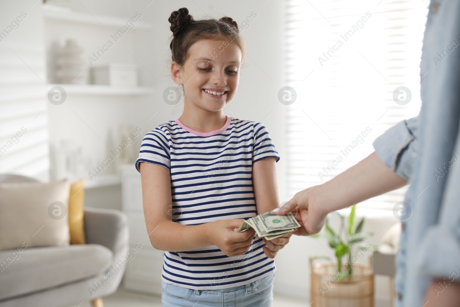 Photo of Mother giving pocket money to her daughter at home