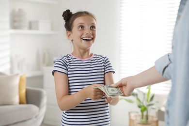 Mother giving pocket money to her daughter at home