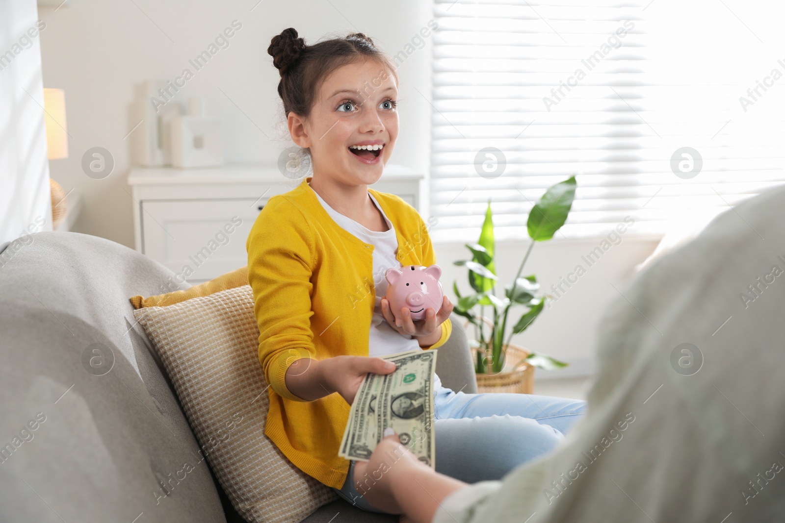 Photo of Mother giving pocket money to her daughter at home