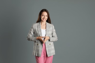 Photo of Beautiful woman in stylish jacket and pink pants on grey background