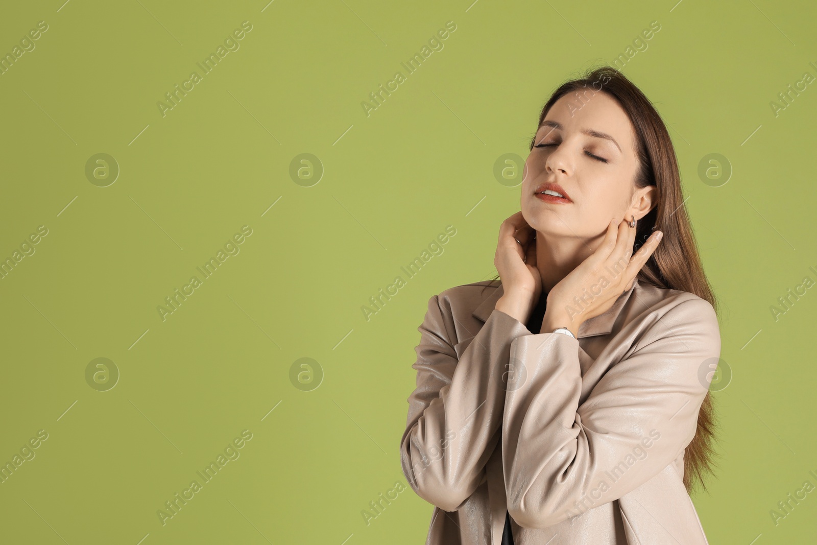 Photo of Beautiful woman in stylish beige jacket on olive background, space for text