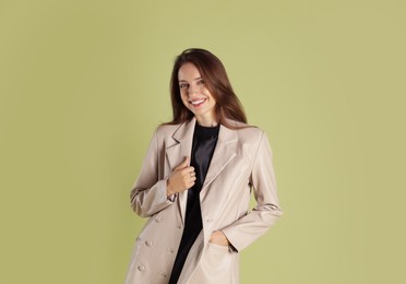 Photo of Beautiful woman in stylish beige jacket on olive background