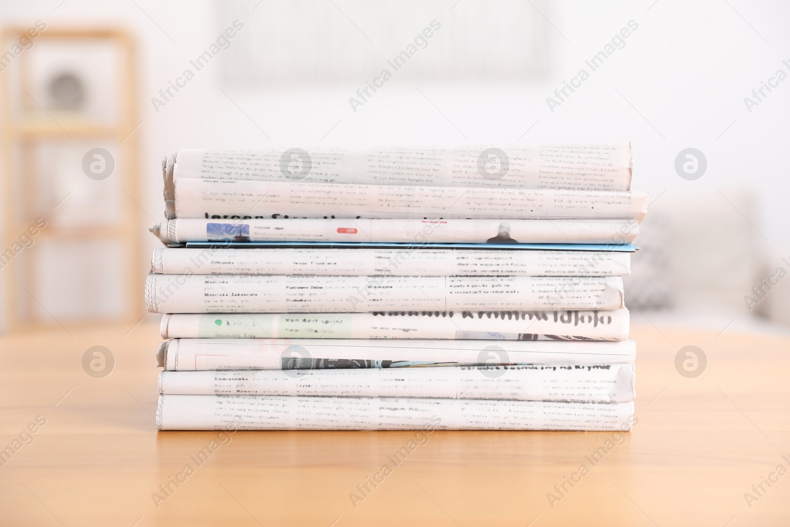 Photo of Stack of many newspapers in different languages on wooden table