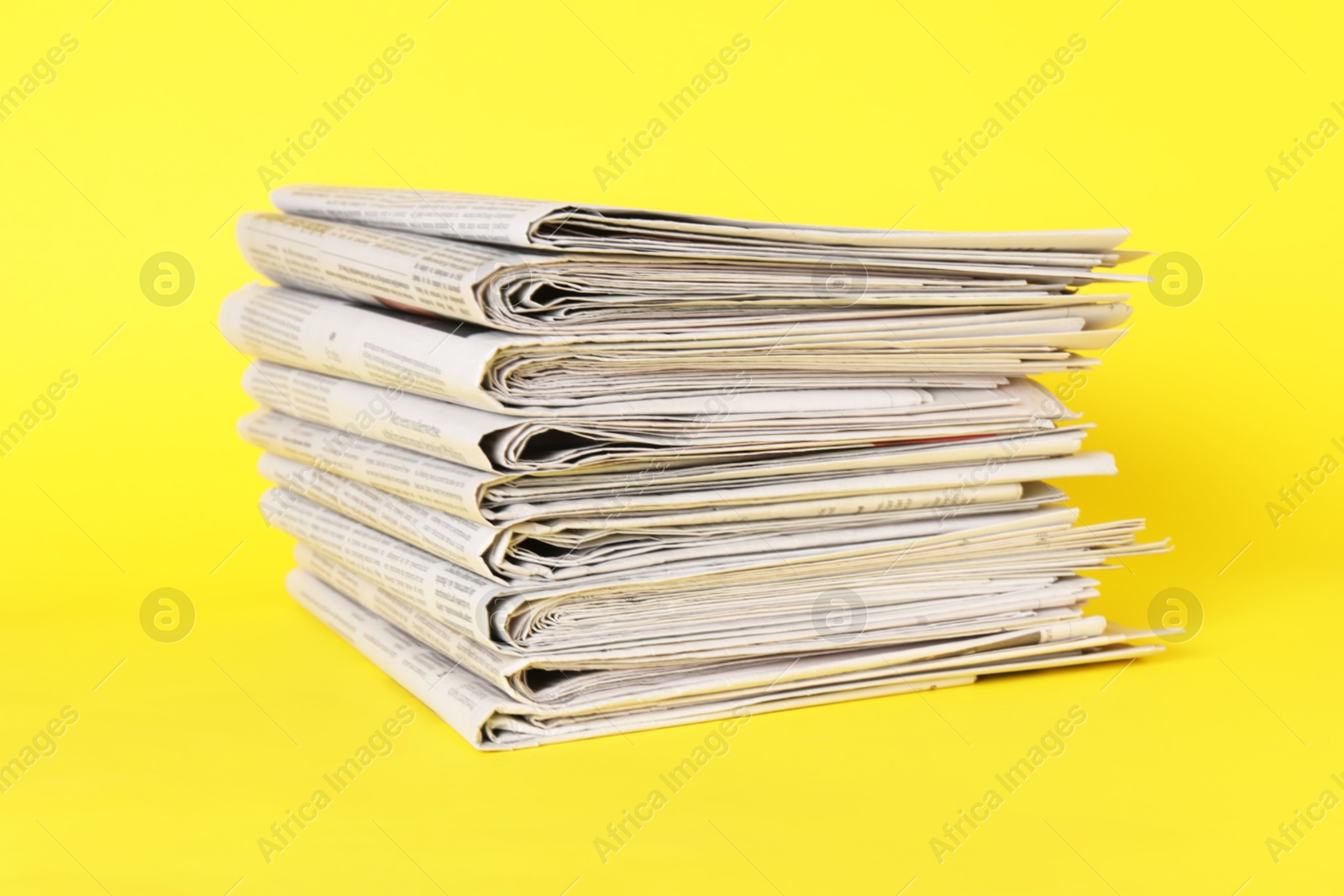 Photo of Stack of many newspapers on yellow background