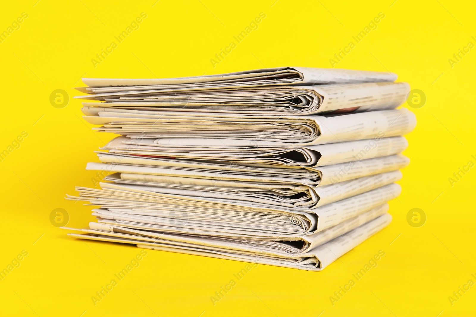 Photo of Stack of many newspapers on yellow background