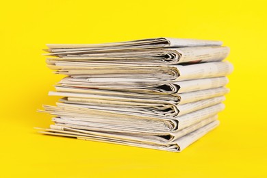 Stack of many newspapers on yellow background