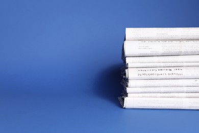 Photo of Stack of newspapers in different languages on blue background, space for text