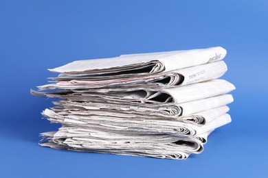 Stack of many newspapers on blue background