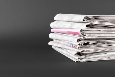 Photo of Stack of many newspapers on grey background, space for text