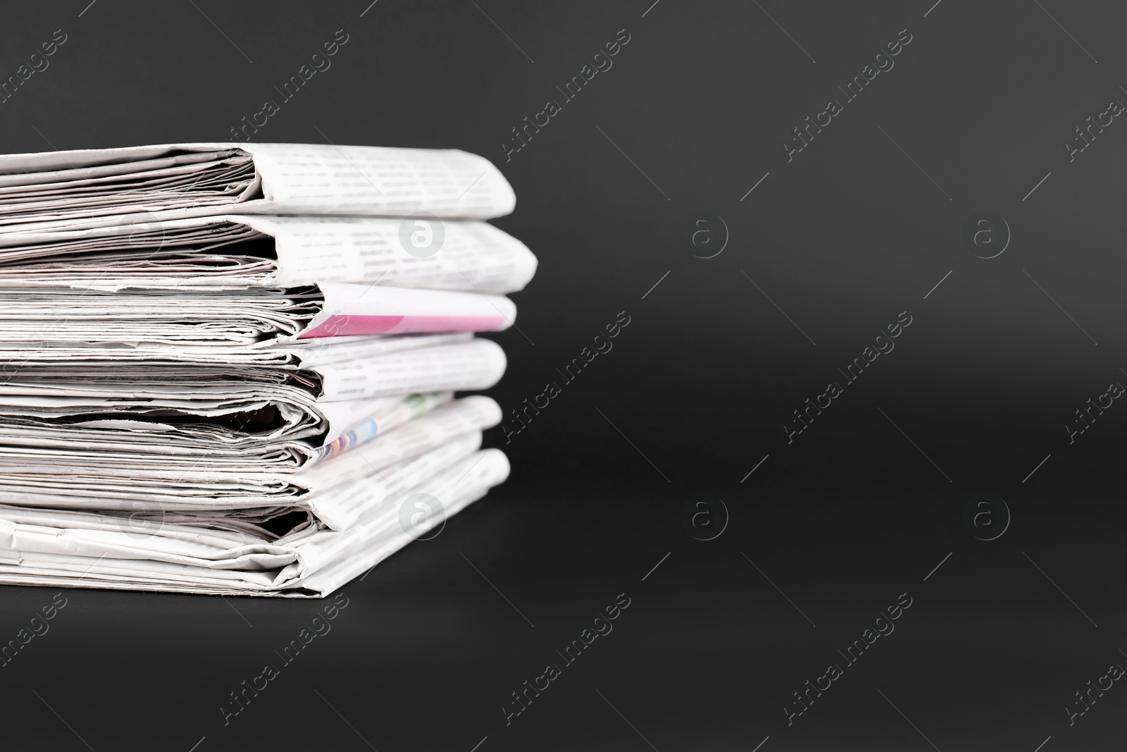 Photo of Stack of many newspapers on grey background, space for text