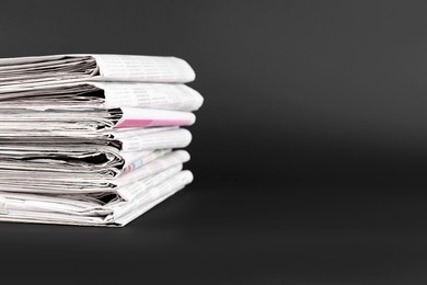 Photo of Stack of many newspapers on grey background, space for text