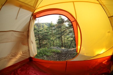 Photo of Modern camping tent in wilderness at summer, view on forest through window