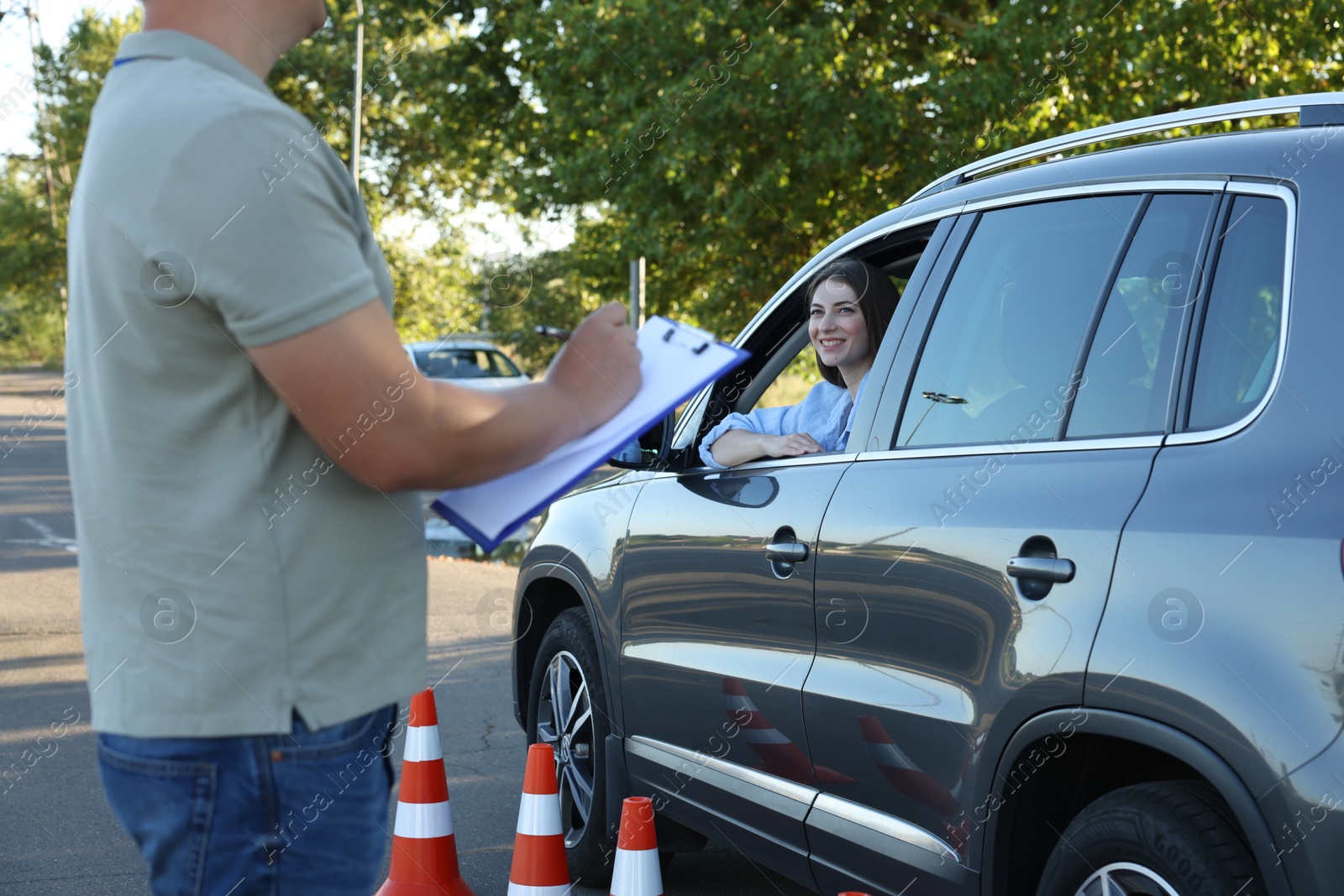 Photo of Examiner with clipboard during exam at driving school test track, closeup