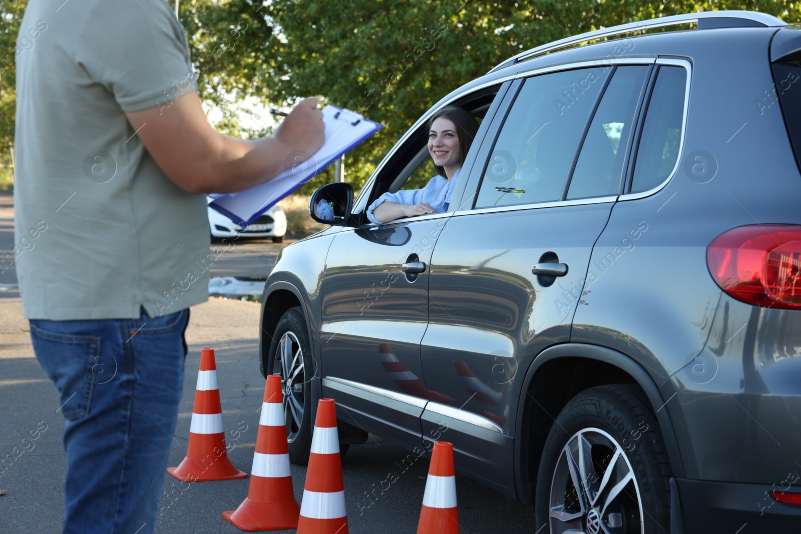 Photo of Examiner with clipboard during exam at driving school test track, closeup