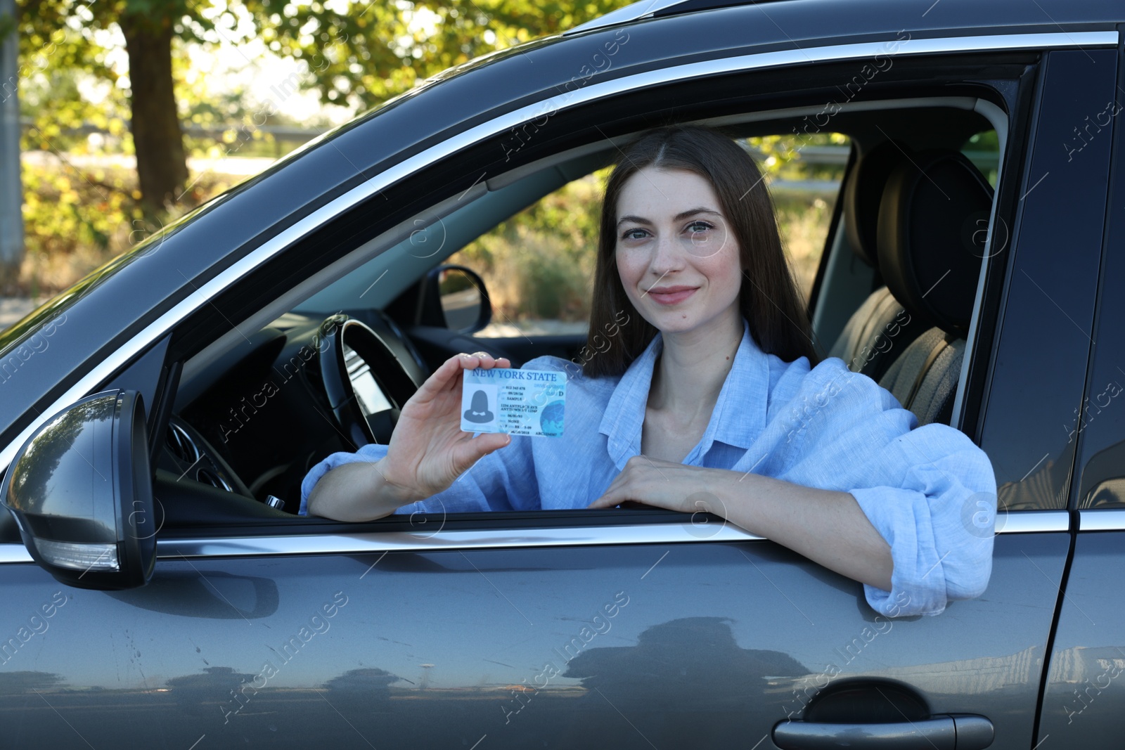 Photo of Driving school. Woman with driving license in car