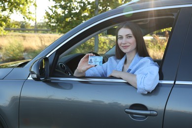 Driving school. Woman with driving license in car