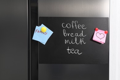 Photo of Magnetic board with shopping list and notes on refrigerator