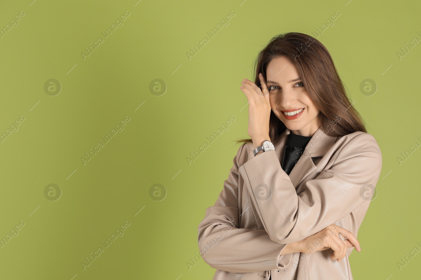 Photo of Beautiful woman in stylish beige jacket on olive background, space for text