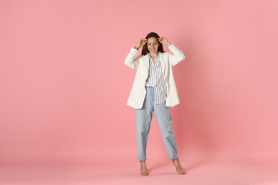 Photo of Beautiful woman in stylish white jacket on pink background