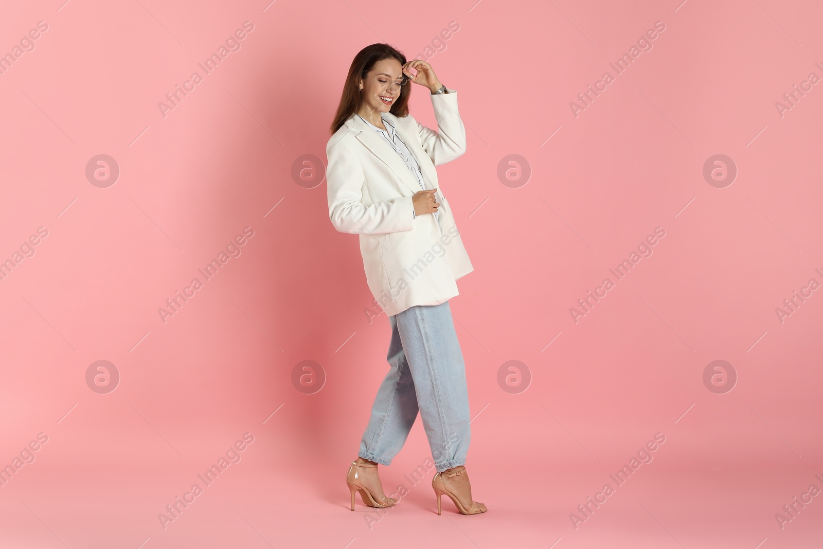 Photo of Beautiful woman in stylish white jacket on pink background