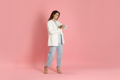 Photo of Beautiful woman in stylish white jacket on pink background, space for text