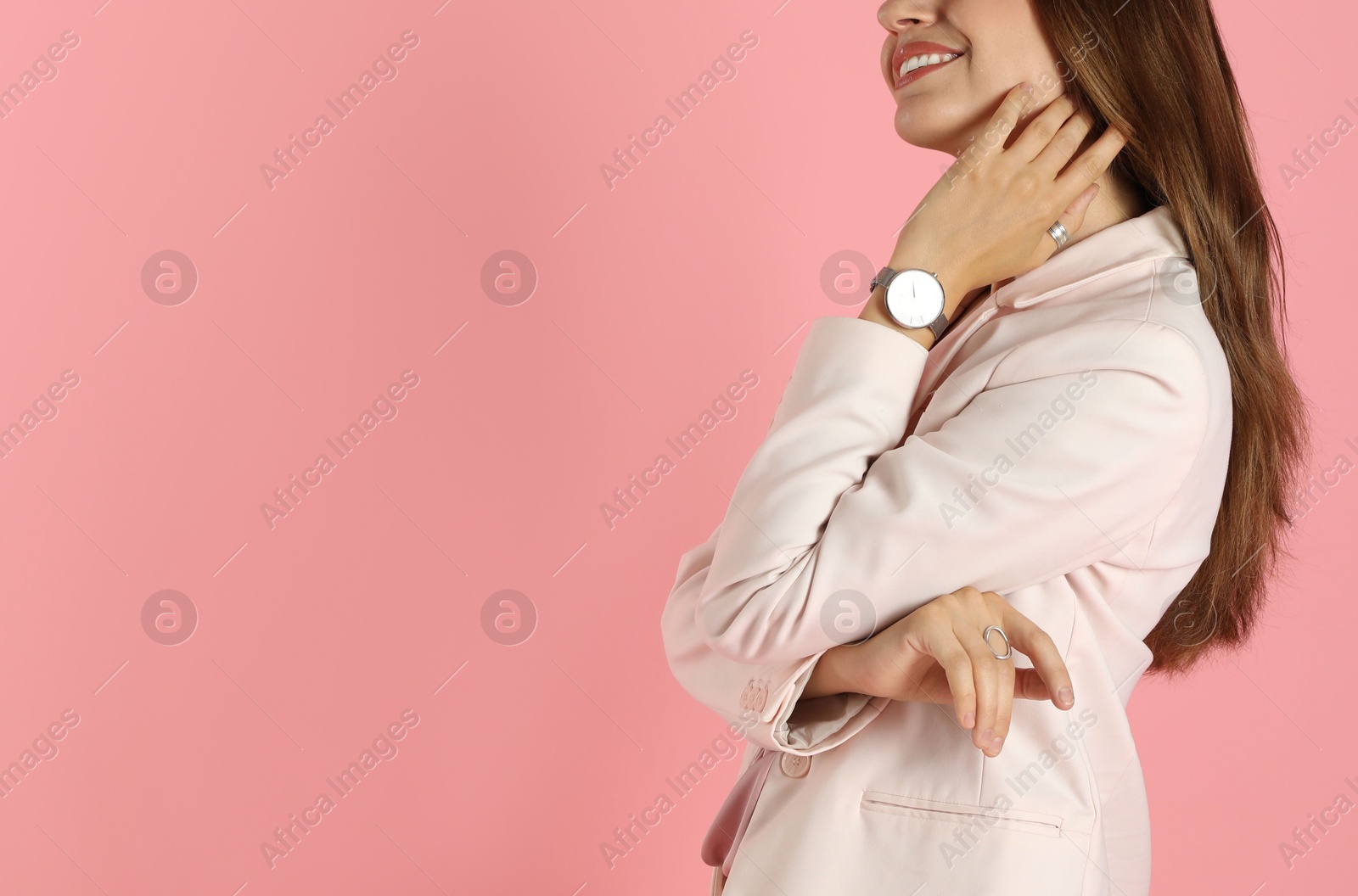 Photo of Beautiful woman in stylish white suit and watch on pink background, closeup. Space for text