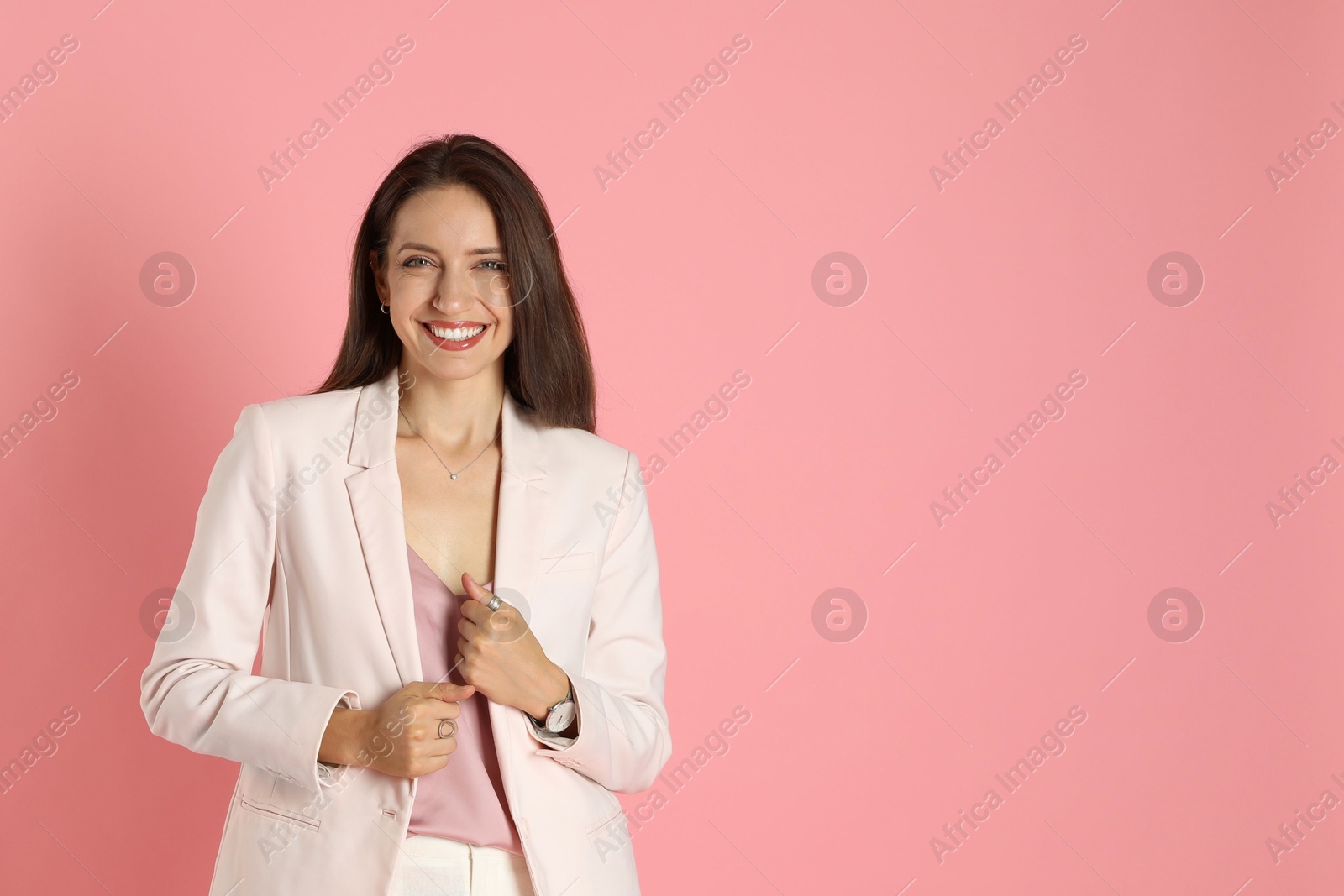 Photo of Beautiful woman in stylish white suit on pink background, space for text