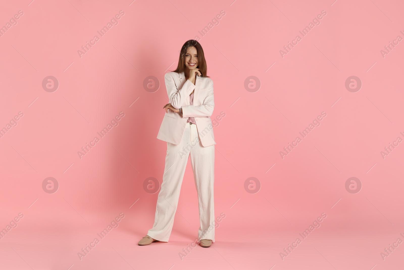 Photo of Beautiful woman in stylish white suit on pink background