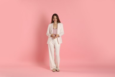 Photo of Beautiful woman in stylish white suit on pink background