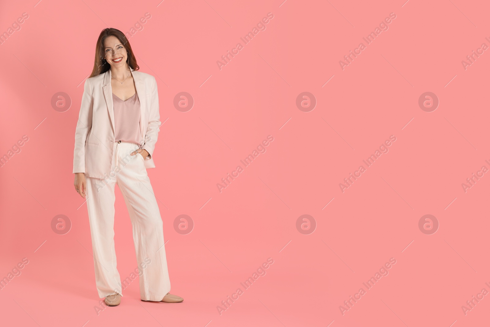 Photo of Beautiful woman in stylish white suit on pink background, space for text