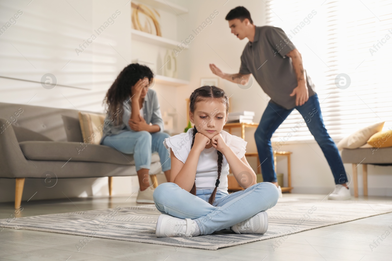 Photo of Divorce concept. Angry couple arguing at home, focus on their sad daughter