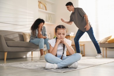 Photo of Divorce concept. Angry couple arguing at home, focus on their sad daughter