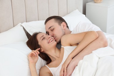 Cute couple lying in bed at home