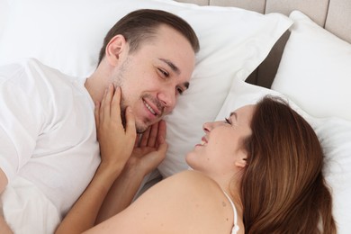 Cute couple lying on bed at home