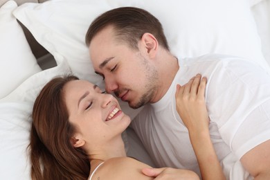 Photo of Cute couple lying on bed at home