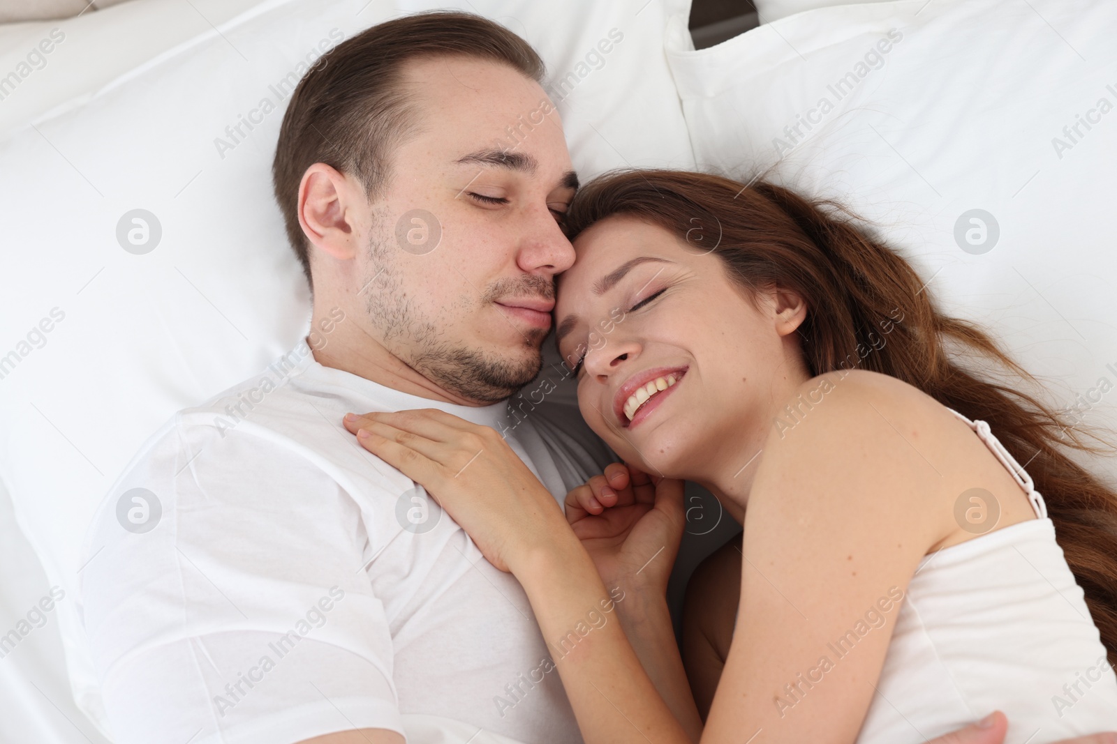 Photo of Cute couple lying on bed at home