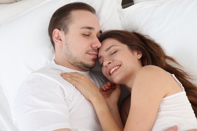 Cute couple lying on bed at home