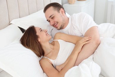 Photo of Happy couple lying in bed at home