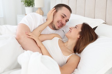 Photo of Happy couple lying in bed at home