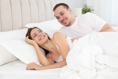 Photo of Happy couple lying in bed at home