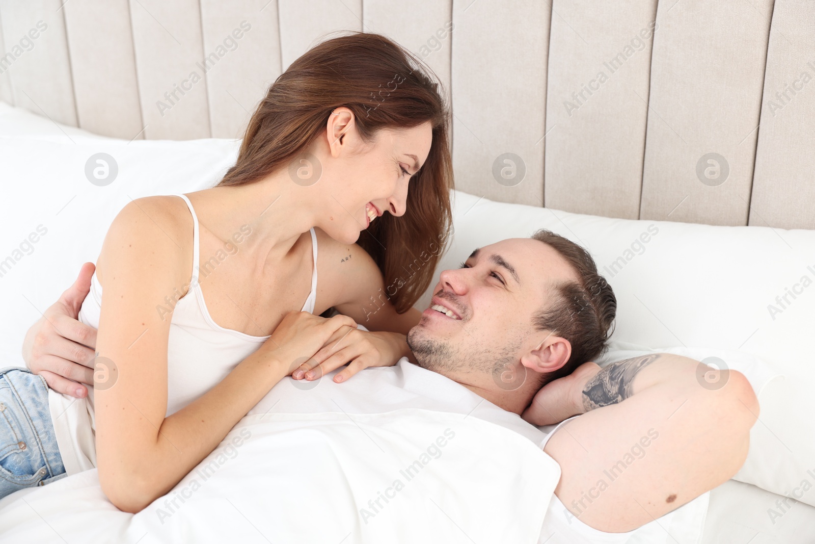 Photo of Happy couple spending time together in bed at home