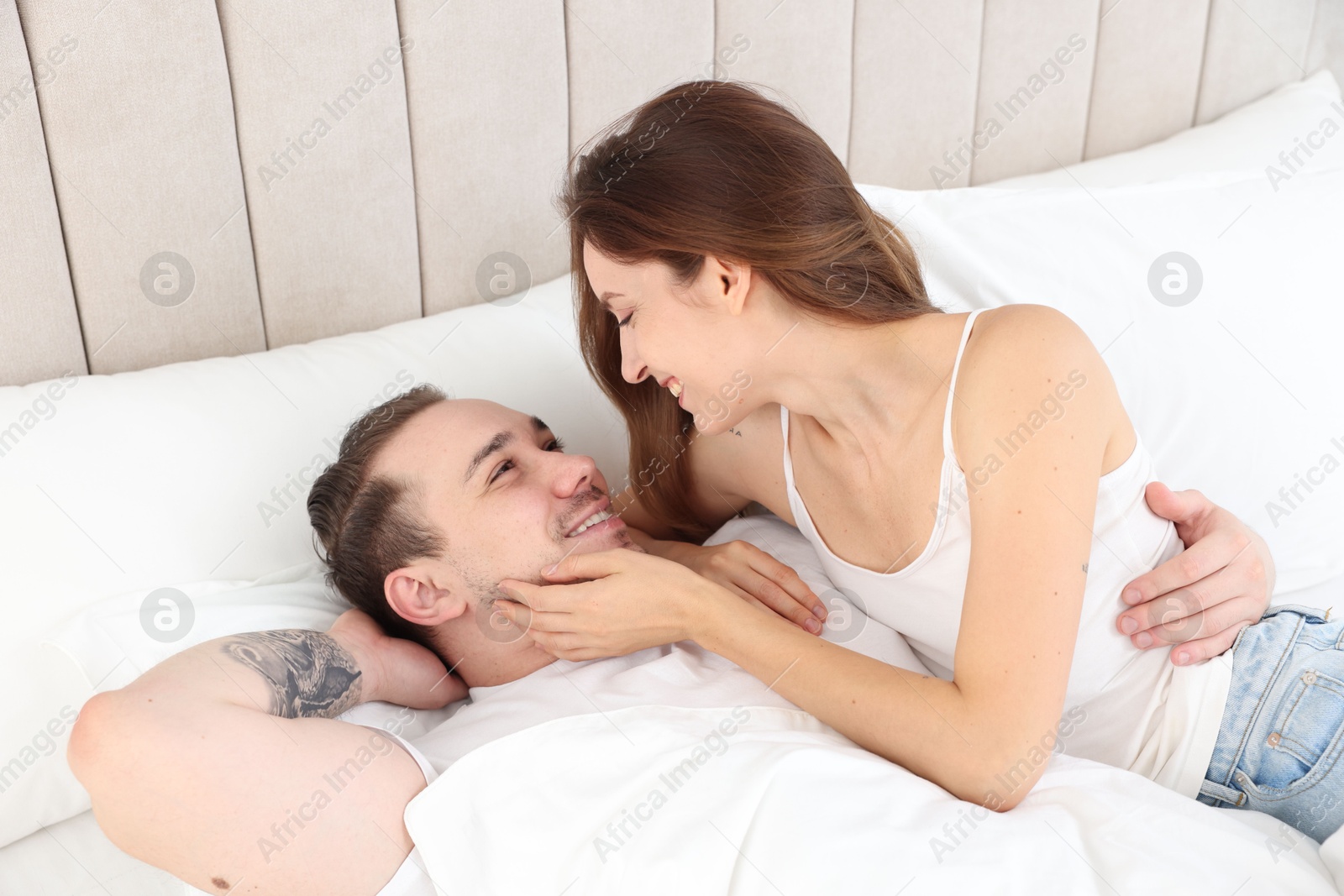 Photo of Happy couple spending time together in bed at home