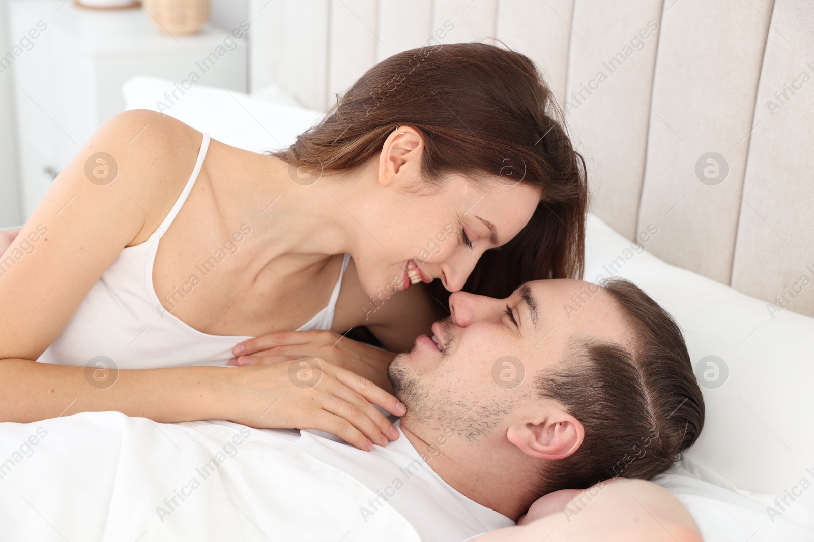 Photo of Happy couple spending time together on bed at home