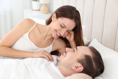 Happy couple spending time together on bed at home