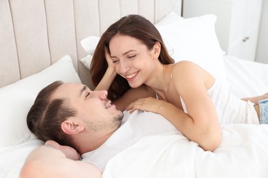 Happy couple spending time together on bed at home