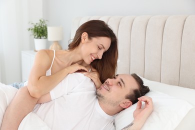 Happy couple spending time together on bed at home