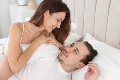 Happy couple spending time together on bed at home