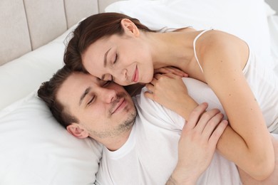 Cute couple lying on bed at home