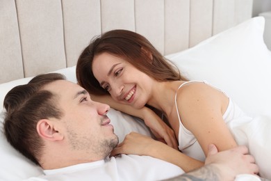 Happy couple lying on bed at home